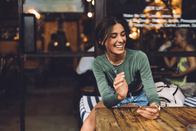 Woman smiling and chatting on mobile phone.